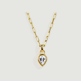 A yellow-gold-tone necklace with an elongated-link chain and a clear teardrop pendant rests against a pale gray background.