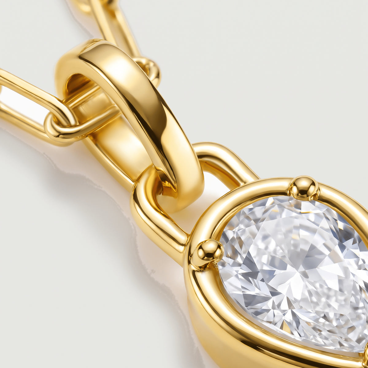 The polished yellow-gold-tone bail and rounded prongs frame a close-up of the clear faceted stone.
