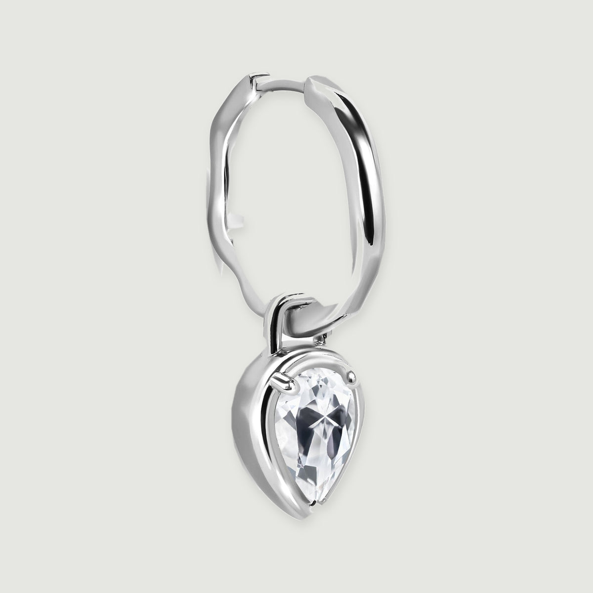 A single silver-toned earring is shown at an angle with its hoop clasp and pear-shaped drop visible.