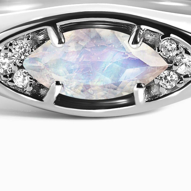 The front of the silver ring shows a pale marquise moonstone between bright clear stone clusters.
