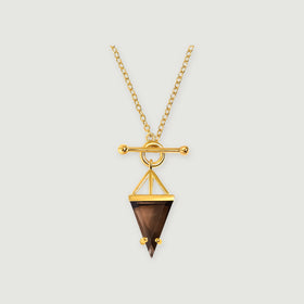 A yellow gold necklace with an oval-link chain, a polished toggle clasp and a triangular smoky quartz pendant rests on a light gray background.