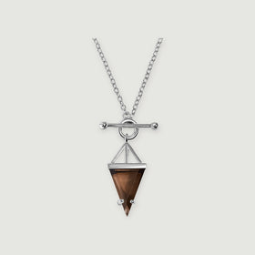 A sterling silver necklace displays a pointed brown smoky quartz pendant beneath a round clasp and horizontal bar on a light gray surface.