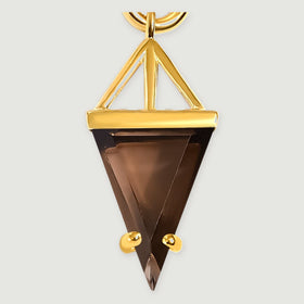 A close view shows the smoky quartz triangle, open gold support and two rounded gold prongs against a pale gray background.