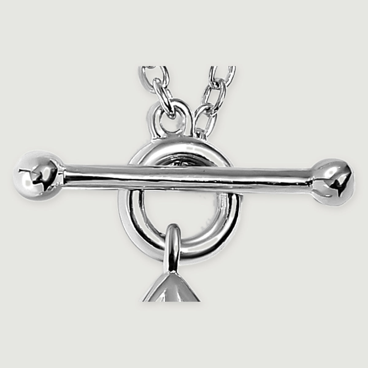 Polished silver ball ends and a horizontal toggle bar sit across a circular ring with oval chain links visible above.