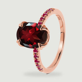 The raised red gemstone and polished rose gold vermeil band are visible from an oblique angle.