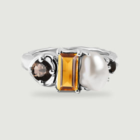 A silver ring shows an amber rectangular stone and a white pearl between dark round accents.