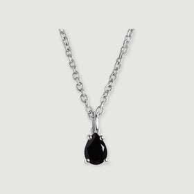 A black pear-shaped pendant with four silver-colored prongs is shown with its oval-link chain on light gray.