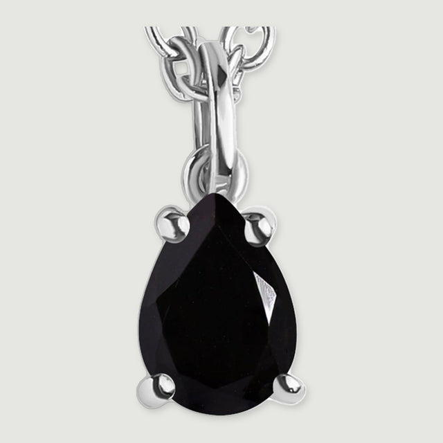 The silver-colored pendant loop and four-prong setting frame a reflective pear-shaped black stone.