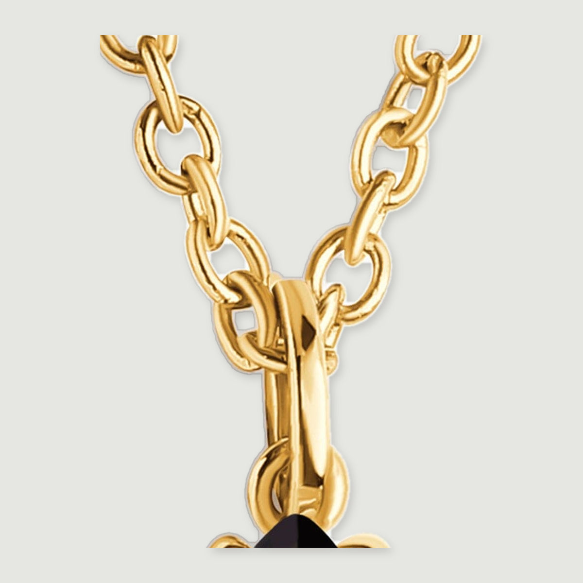 Interlocking yellow gold-colored chain links meet the polished loop above the black pendant.