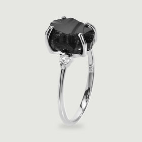 The white gold ring is shown from the side with its open band and raised black stone setting.