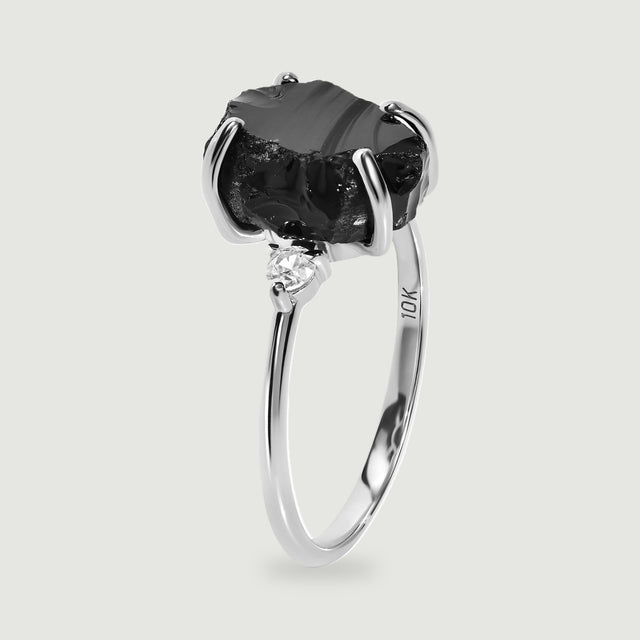 The white gold ring is shown from the side with its open band and raised black stone setting.