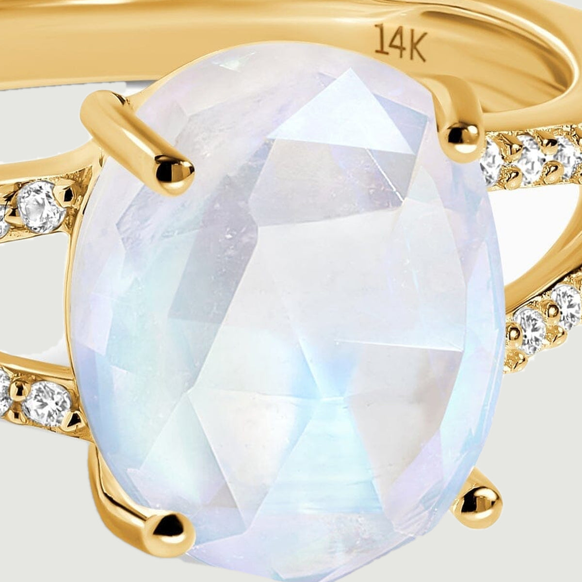Pale blue reflections cross the oval faceted moonstone held by yellow gold prongs.