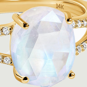 Pale blue reflections cross the oval faceted moonstone held by yellow gold prongs.