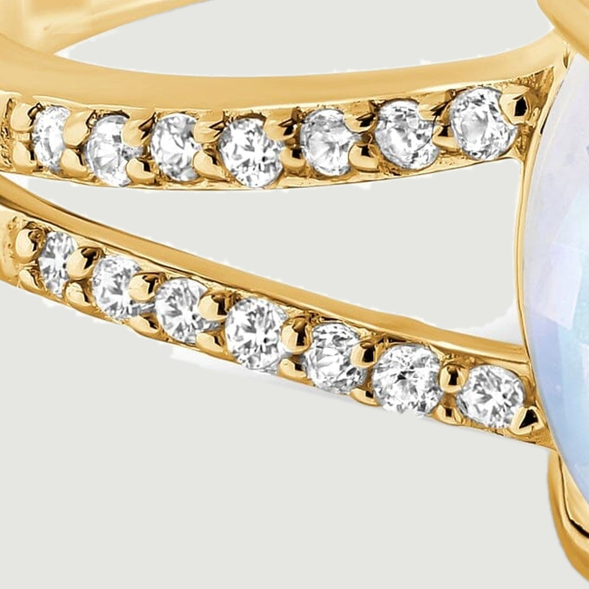 Two rows of small round diamonds follow the split yellow gold shoulder.