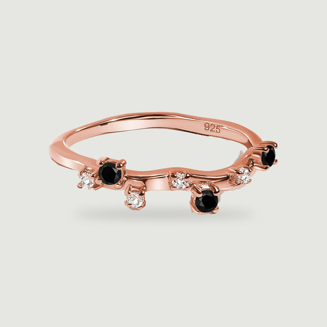 A rose gold vermeil band with alternating black onyx and clear stones in a low three-quarter view.