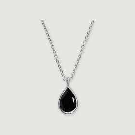 A sterling silver bezel frames a black pear-shaped pendant beneath an oval-link chain on a gray background.