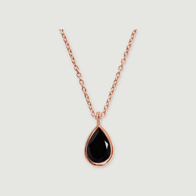 A rose gold vermeil necklace displays a glossy black teardrop stone and a narrow polished bail on light gray.