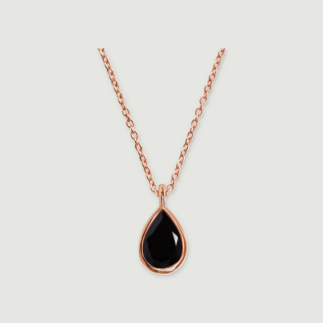 A rose gold vermeil necklace displays a glossy black teardrop stone and a narrow polished bail on light gray.