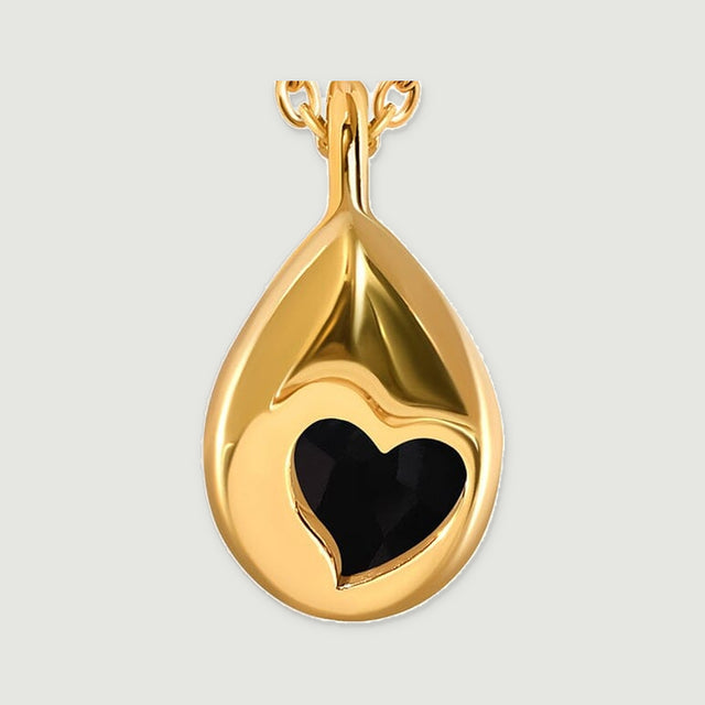 The reverse of the yellow gold vermeil pendant shows black stone through a heart-shaped opening in polished metal.