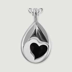 A close view of the silver pendant back reveals a heart-shaped aperture and its smooth curved pear outline.