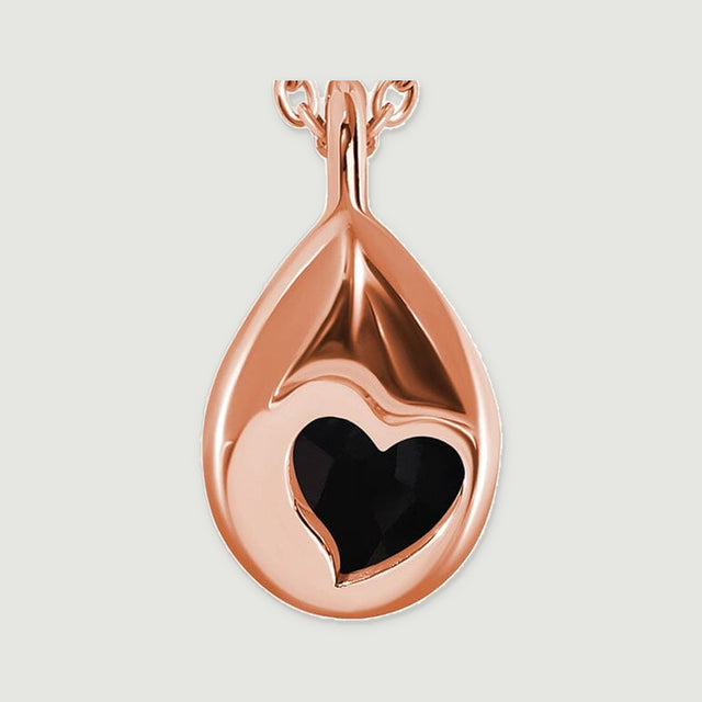 The rose gold vermeil pendant is shown from the back with a heart-shaped opening and a polished tapered bail.