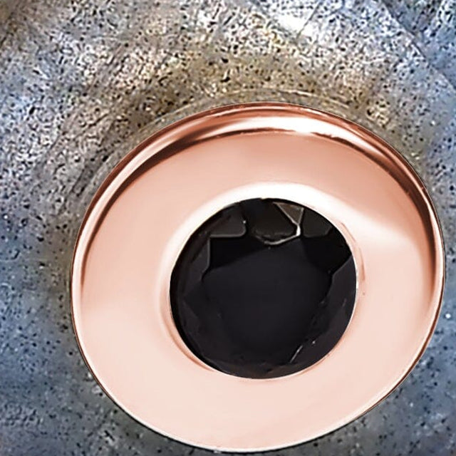 A rose gold vermeil centre bezel encircles a black faceted stone in this detailed view of mottled labradorite.