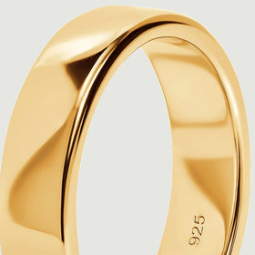 A close view follows the curved upper edge and polished side of the yellow gold ring.
