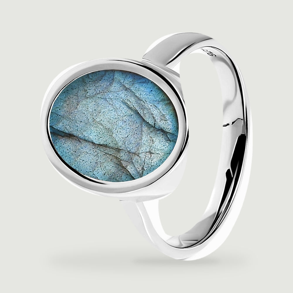 The angled silver ring shows its raised oval setting and curved polished band.