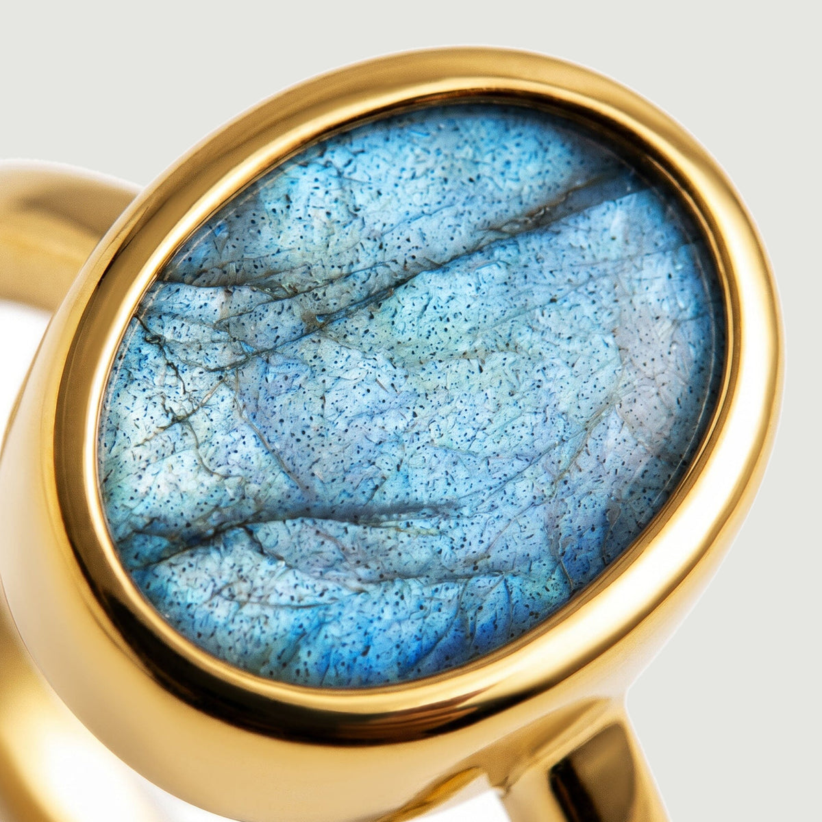 Dark natural lines cross the blue labradorite inside a smooth yellow gold vermeil bezel.