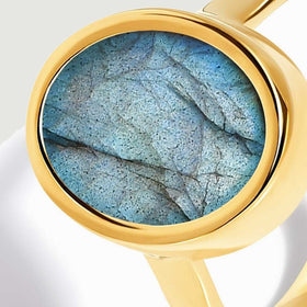 The oval blue stone is shown nearly face on with a broad yellow gold vermeil rim.