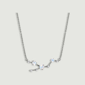 A silver necklace has polished connecting bars and round prong-set stones against a softly shaded grey background.
