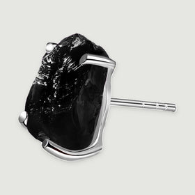 An angled silver stud exposes its open setting and the straight post behind the black stone.