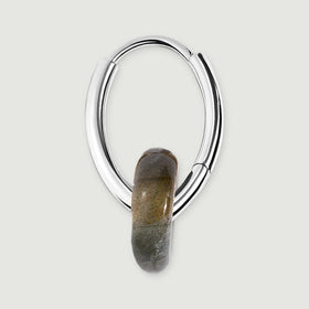 The side of a silver-tone earring reveals its curved hoop, hinged section and smooth gray stone edge.