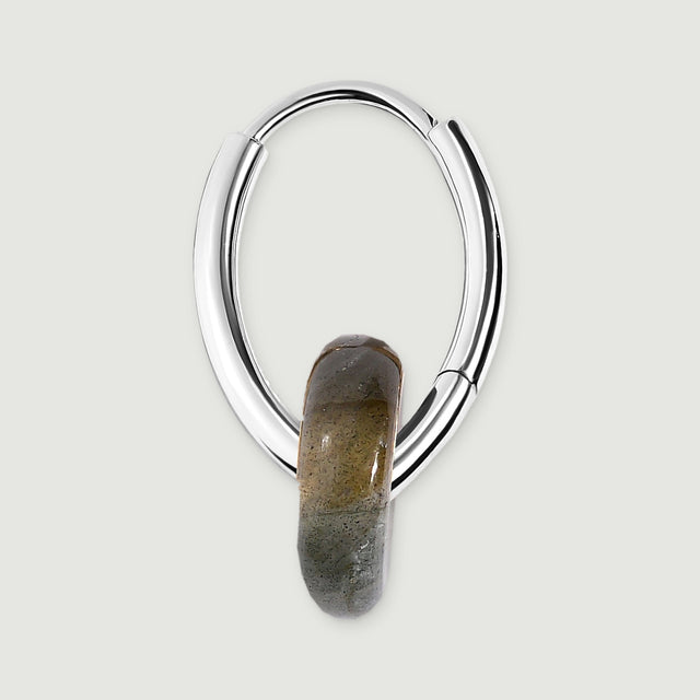 The side of a silver-tone earring reveals its curved hoop, hinged section and smooth gray stone edge.