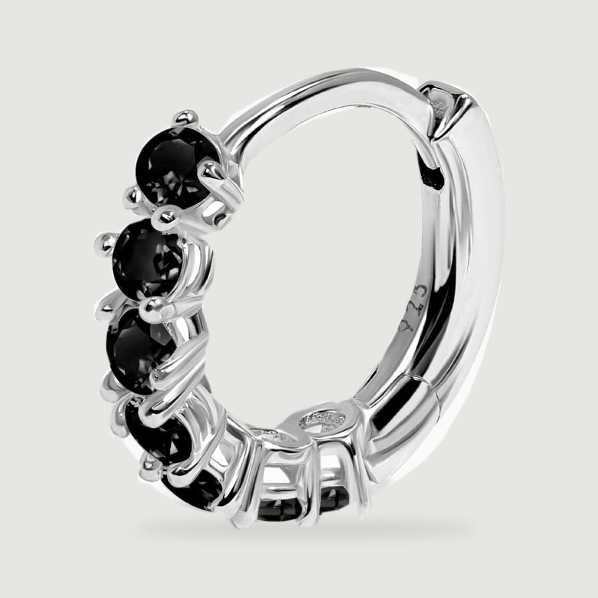 A sterling silver hoop earring is shown at an angle with black stones, a curved inner band and a hinged clasp.