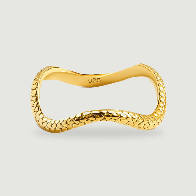 A complete yellow gold ring shows its textured front and smooth inner band against light gray.