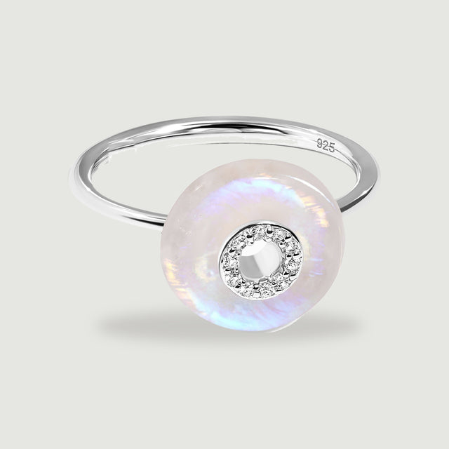 A silver ring with a round pale moonstone disc, a clear stone halo and a visible 925 hallmark.