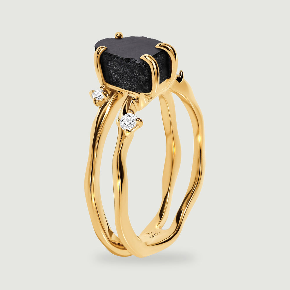 The side of a yellow gold vermeil ring shows the raised black stone and two curved bands.