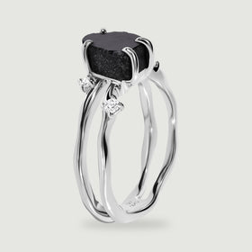 A side view of the sterling silver ring reveals its open band and polished stone claws.