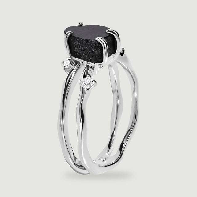 A side view of the sterling silver ring reveals its open band and polished stone claws.