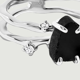 Two clear round stones sit beside the curved sterling silver bands in this close detail.