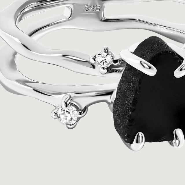 Two clear round stones sit beside the curved sterling silver bands in this close detail.