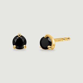 Round black obsidian earrings with yellow gold prongs are arranged to reveal their fronts and one post.