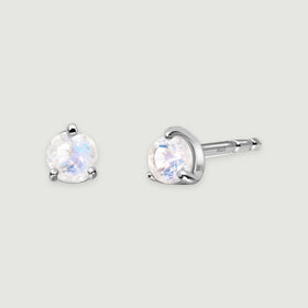 Two round moonstone studs in polished silver sit side by side, with the post visible on the right.
