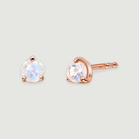 Rose gold moonstone studs are arranged as a front-facing earring beside an angled earring with its post exposed.