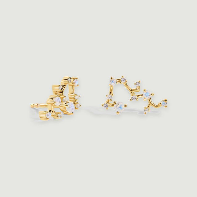 A pair of yellow gold stud earrings displays branching polished bars, pale blue stones, and small clear gems.