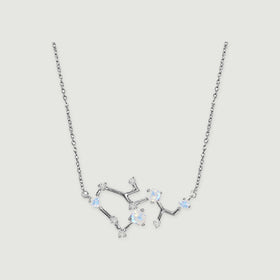 A silver necklace with a fine link chain and an open branching pendant rests against a light gray background.
