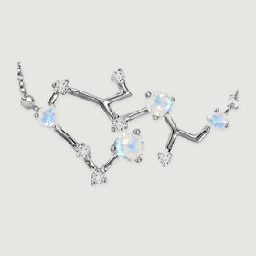 Silver prongs and polished connecting bars surround pale blue and clear stones in this pendant close-up.