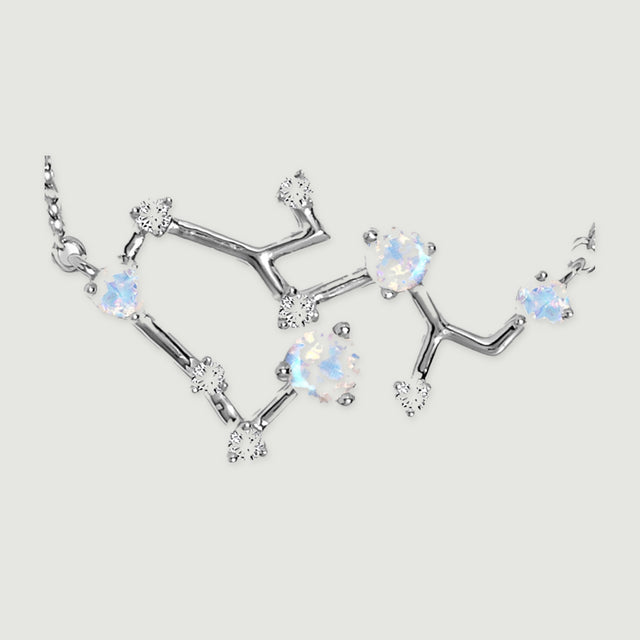 Silver prongs and polished connecting bars surround pale blue and clear stones in this pendant close-up.