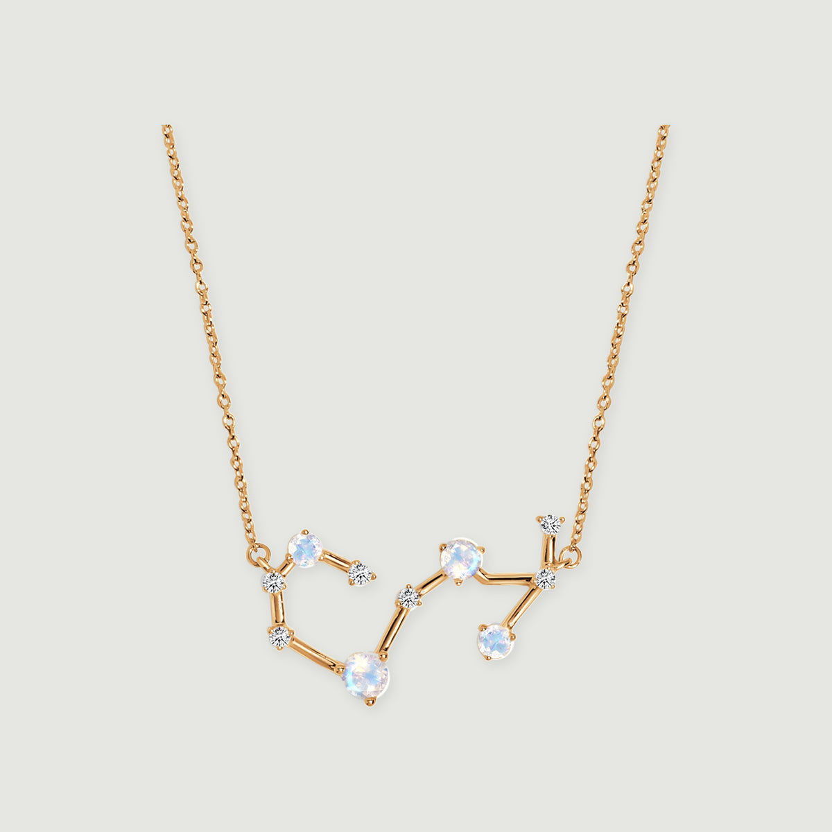 A yellow gold necklace displays an angular constellation with four pale round stones and smaller clear stones.